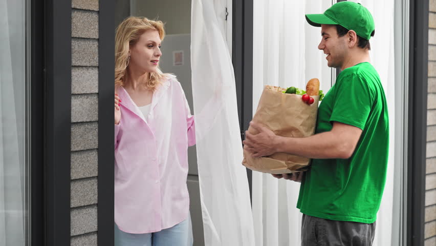 Girl meet food delivery man. Fast grocery deliver e service. Woman buy diet vegetable product. Courier guy give meal craft pack. Vegan city street shop. Fresh eco farm veggie delivery. Home order bag.