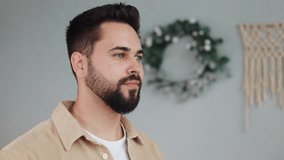 Portrait young handsome bearded man in casual clothes turning head smiling look at camera feel happy on christmas background at home. New year winter holidays. Celebrating Eve. Merry Christmas. - Powered by Shutterstock - Get 15% off with code: PIKWIZARD15