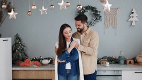 Thoughtful husband tenderly approaches his wife, wrapping her in a woolen cape to ensure her warmth. Together in their festively decorated kitchen, revel in the festive ambiance and mutual comfort. - Powered by Shutterstock - Get 15% off with code: PIKWIZARD15