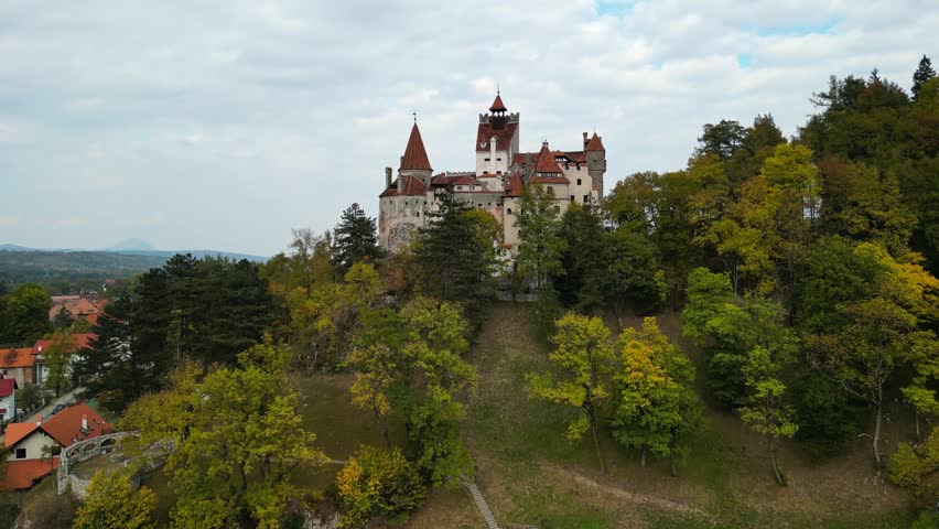 Aerial drone view of The Bran Castle in Romania. Dracula's castle in Transylvania during the autumn. Medieval Bran Castle in Brasov region. Popular tourist place. Royalty-Free Stock Footage #1109961385