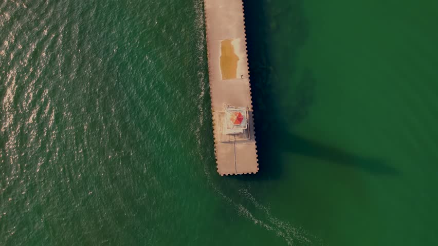 Drone shot spin around of the small light house at Sodus point New York vacation spot at the tip of land on the banks of Lake Ontario.