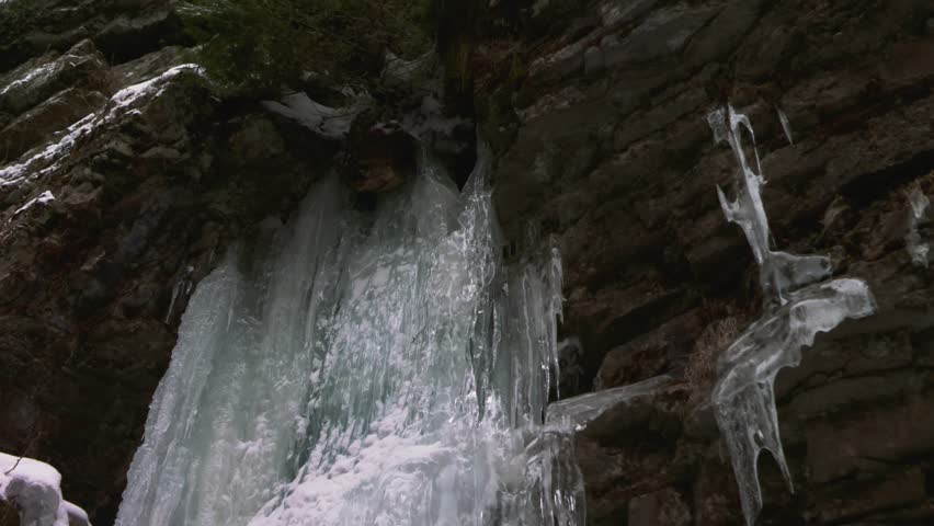 Frozen waterfall with icicle covered cliff and rocks, Ausable Chasm, Adirondacks
