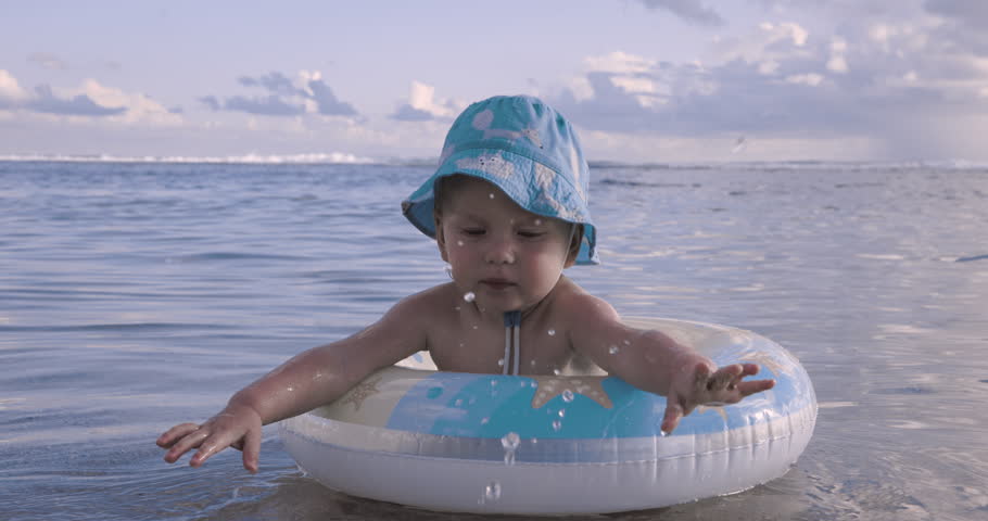 Baby Swims On An Inflatable Circle In The Ocean