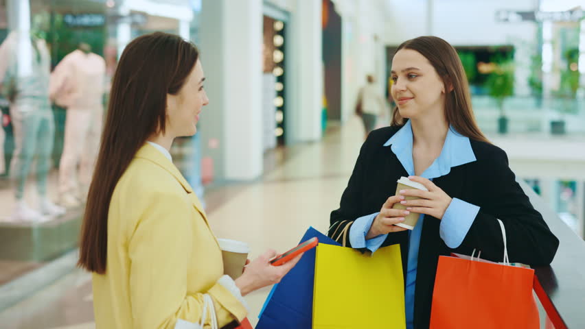 Two female buddies are at the shopping mall. The ladies are enjoying their coffee, sharing laughter, and engaging in conversation. The happy woman is chatting with her stylist after a shopping spree Royalty-Free Stock Footage #1109967151