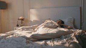 Smiling girl waking up in morning sunlight. Happy positive woman checking mobile phone enjoy lazy holiday in bed. Pretty joyful model getting up full of energy on weekend. Awake female use smartphone - Powered by Shutterstock - Get 15% off with code: PIKWIZARD15