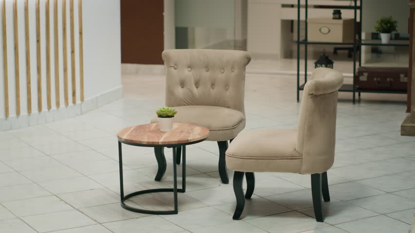 Lounge area with luxury armchairs in hotel decorated with modern expensive furniture, elegant design and decorations. Empty lobby entrance with front desk and marble floors.