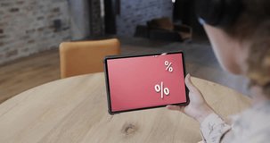 Biracial woman using tablet at cafe online shopping during sales, slow motion. Retail business, sale, communication and digital interface digitally generated video.