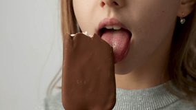 Child with ice cream on a white background. Cute little girl enjoys a delicious popsicle ice cream stick, 4k