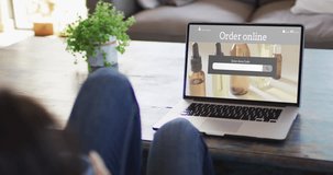 Woman at table using laptop, online shopping for beauty products, slow motion. Retail business, sale and digital interface digitally generated video.