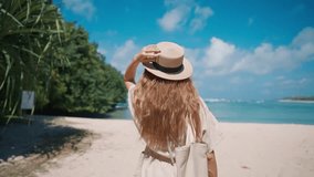 Romantic blonde woman tourist in straw hat walking to ocean sandy beach in sunny day, rear view. Female lady enjoying nature on vacations summer holidays. Travel, tourism, journey, rest relax concept. - Powered by Shutterstock - Get 15% off with code: PIKWIZARD15