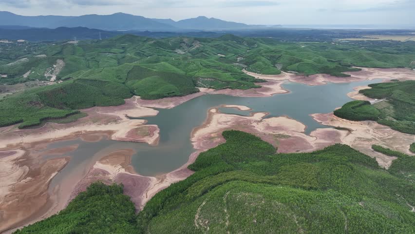 Dry lake bottom in summer, revealed red soil in the leke center. Vietnam.