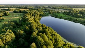 Rural landscape with country houses. Lake in countryside on sunset, aerial view. Green nature at Lake. Drone shot flying over country House in rural. Bird's eye view of agricultural field in rural. - Powered by Shutterstock - Get 15% off with code: PIKWIZARD15