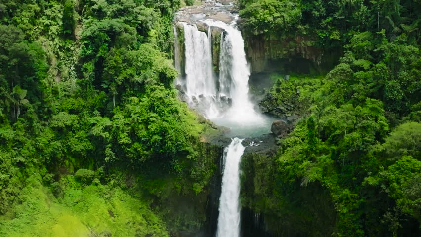 Two- tiered waterfall in mountain forest, slow motion view. Limunsudan Falls. Mindanao, Philippines.
