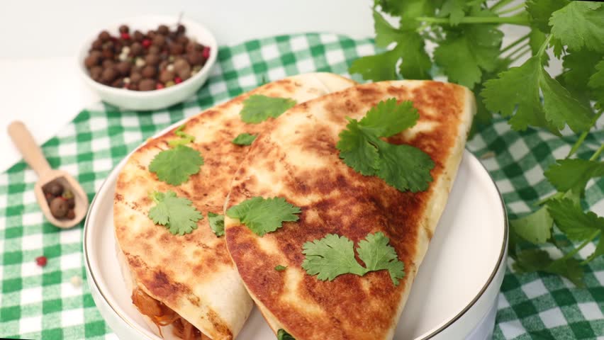 Quesabirria tacos is a Mexican dish that consists of spicy, shredded beef and melted cheese, fresh cilantro, enclosed in tortillas,  rotation in circle. a plate of tacos, Turning