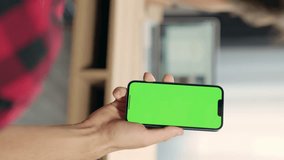 Close Up of Smartphone with Green Screen Mock Up Display In Male Hands. Man Sitting In Office Browsing Internet , Watching Content, News, Financial Reports on Phone