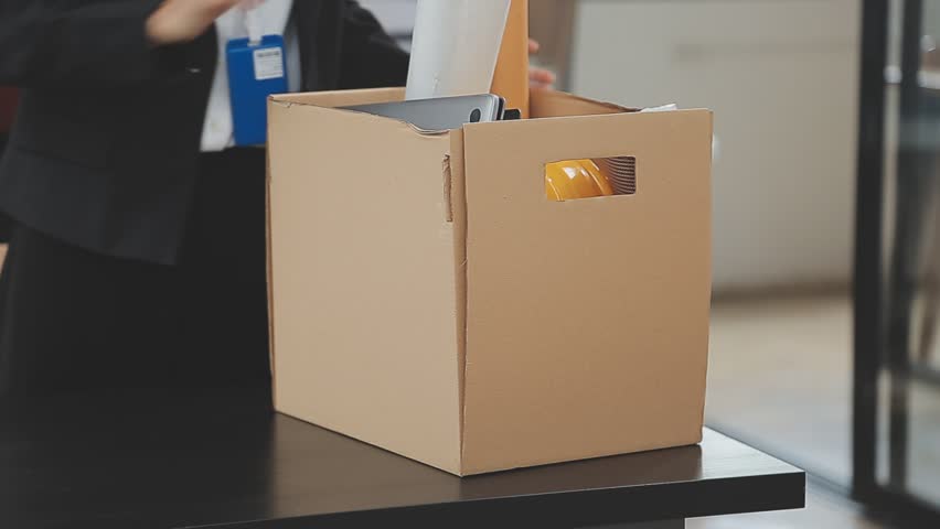 Business woman sending resignation letter and packing Stuff Resign Depress or carrying business cardboard box by desk in office. Change of job or fired from company. Royalty-Free Stock Footage #1110009231