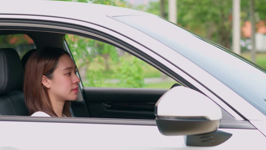 Happy Asian woman sitting in car behind steering and wave hand. Concept of happy driver, car insurance service. Customers excited after buying new car, new drivers excited for successful car license Royalty-Free Stock Footage #1110009935