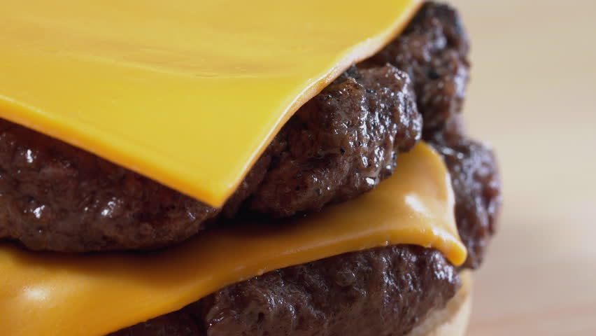 Cheese Melting on Burger: Savor the Irresistible Delight Indulge in the mouthwatering experience of hot, gooey cheese melting over a delicious burger. 