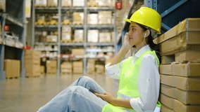 Asian woman worker listening to music using mobile phone at the break, enjoying inventory management in depot with racks and shelves. Female employee having fun dancing on songs, using headphones. - Powered by Shutterstock - Get 15% off with code: PIKWIZARD15
