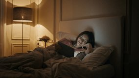 Cheerful woman watching tablet in bed. Happy female laughing movie in evening bedtime. Relaxed sleepy woman looking digital computer enjoying funny show at night. Home entertainment leisure concept - Powered by Shutterstock - Get 15% off with code: PIKWIZARD15