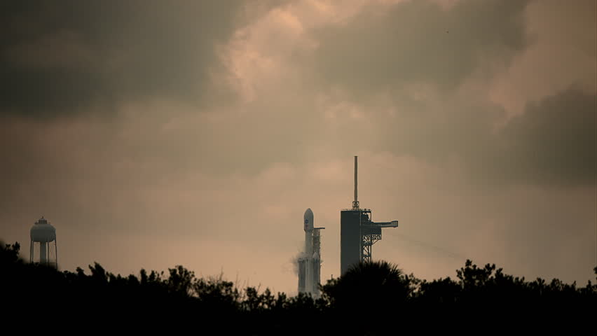 Spectacular shot of a Falcon Heavy Space Rocket blasting off from launch pad as it flies to space on its mission to psyche asteroid.  4K. Slow-motion. Includes sound and audio.