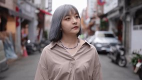 Slow motion video of a young Taiwanese woman with gray hair strolling through the old streets of Dihua Street.