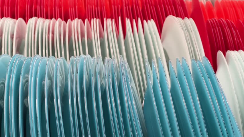 New round plates lined up in rows on the shelf in a crockery store or tableware shop. Close up