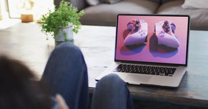 Knees of woman at table using laptop, online shopping for gamepads, slow motion. Retail business, sale, communication and digital interface digitally generated video.