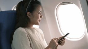 Businesswoman female passenger of airplane using networks via smartphone wifi on board, young girl sending message on phone solo traveling by plane. Traveling technology concept - Powered by Shutterstock - Get 15% off with code: PIKWIZARD15