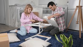Love couple assembly new home ikea furniture. Family moving into house. Joyful guy buy hand made chair. Girl sit floor. People do kitchen renovation. Man rent flat. Team work craft diy. Manual repair. - Powered by Shutterstock - Get 15% off with code: PIKWIZARD15