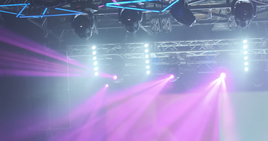 Pink rays motion of spotlights light in nightclub. Show illuminated with bright spotlight. Magenta spot light glow, shine on blue background. Professional lighting technology. Lamp beam moving video Royalty-Free Stock Footage #1110041013