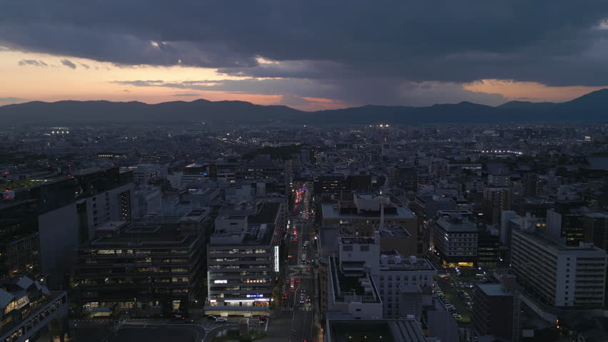 flying back from dusk view of Kyoto revealing illuminated Kyoto Tower