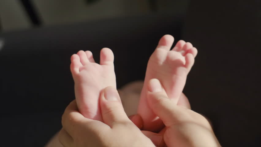 Close up of masseur massaging little baby foot lying on sofa. Unknown loving mother massaging baby finger feet. Caring mom doing massaging infant boy at home. Newborn child about 4-6 months old Royalty-Free Stock Footage #1110049785