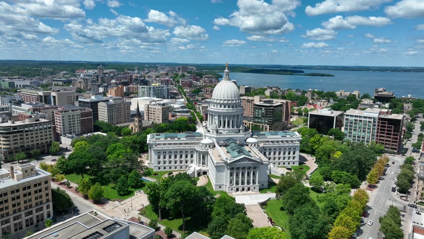 Aerial view of Madison, showcasing the stunning Capitol building amidst the cityscape, with the serene backdrop of lakes and greenery. Capitol building of Wisconsin on beautiful summer day. Drone shot