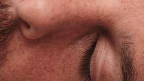 Vertical video, Detailed close-up half face shot of man's opening eye and looking at camera in studio - Powered by Shutterstock - Get 15% off with code: PIKWIZARD15