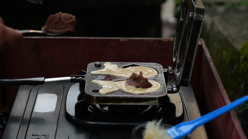 Korean style pancake (Bungeoppang) ,Fish-shaped bread with sweet red bean filling in South Korea,street food. Winter food - Hand preparing cooking Bungeoppang (fish-shaped bread) Royalty-Free Stock Footage #1110061855