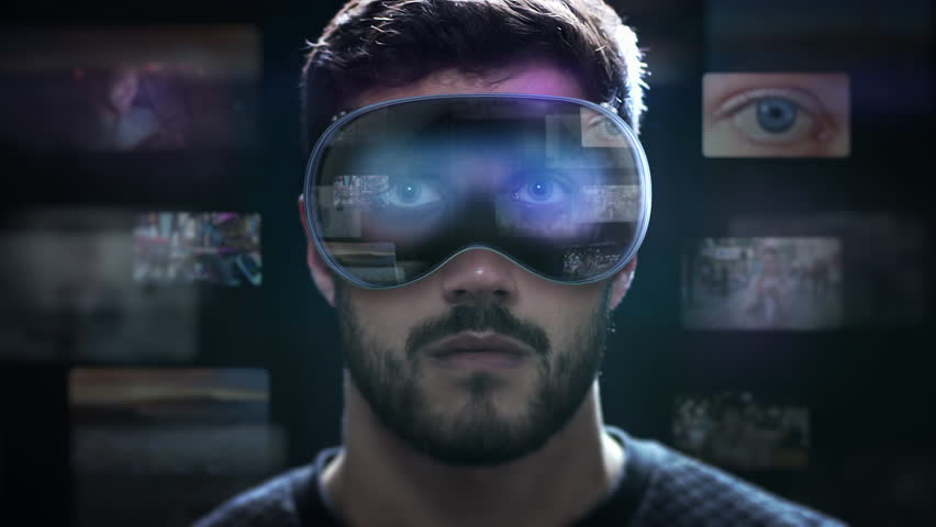 
Young Latin American Male Checking Social Media Posts and Videos on His Hi Tech Virtual Augmented Reality Glasses. Holographic Screens Appearing in VR Headset. Metaverse.
