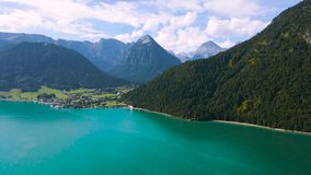 Aerial footage of the beautiful Achen Lake in Tyrol, Austria. Video of the lake was shoot from a drone while flying forward, from above. In the footage can be seen the lakes blue color and mountains.