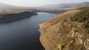 Drone footage skims over the waters of Aparan Reservoir during autumn, capturing the shimmering reflections of autumnal hues and the serene ambiance of the season