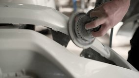 Sanding a car part. Close-up: an auto mechanic sands car parts for painting. Body work, car repair, painting after an accident. Sanding a car body part with an electric sander before painting. - Powered by Shutterstock - Get 15% off with code: PIKWIZARD15