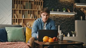 Anxious man looking on laptop drinking coffee at home late evening. Serious tired freelancer working at computer solving business issues remotely. Attractive young programmer thinking on job solutions - Powered by Shutterstock - Get 15% off with code: PIKWIZARD15