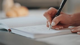 Woman hands writing in notebook holding black ballpen closeup. Unknown businesswoman working modern laptop making notes in notepad at office desk. Unrecognizable accountant noting information on paper - Powered by Shutterstock - Get 15% off with code: PIKWIZARD15