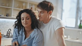 Beautiful wife feeding husband with apple slice standing at cozy kitchen. Happy married couple spending family morning together preparing breakfast. Loving spouses enjoy tenderness at home close up. - Powered by Shutterstock - Get 15% off with code: PIKWIZARD15