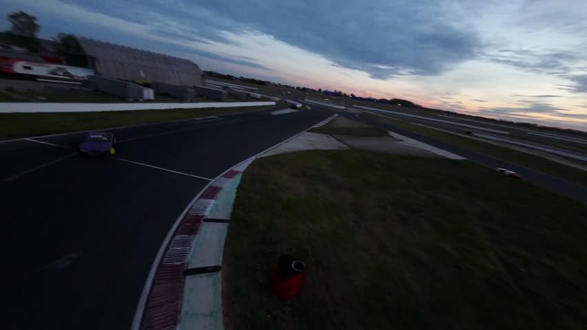 drift training cars driving along the track in a skid on the asphalt in a skid filming with an FPV drone along the podium race speed competition
