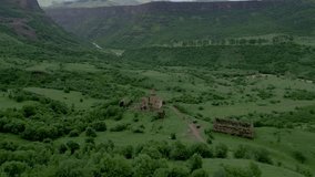 Gnevank Monastery near the village of Kurtan in Lori Armenia. Located in the green deep gorge of the Dzoraget and Gargar rivers in cloudy weather. Drone video. Flying in an arc, distant plan.