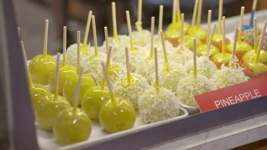 This video shows a display window lined with fun and colorful fruit flavored candied apples.
