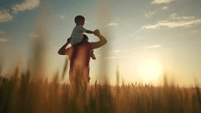 dad holds baby on his neck. landscape nature fresh air sun glare. fun family time. dad plays a with son happy family dream content lifestyle