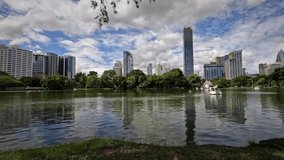 Beautiful Timelapse Video Of A Swan Lake In Lumphini Park, Bangkok Thailand. Peddle Boats Dancing Above A Lake Reflecting The City Skyline.