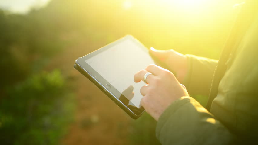 Outdoor, closeup and man with a tablet, typing and lens flare with connection, network and website information. Person, hands and guy with technology, social media and email notification with nature