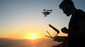 Sunset, space and a man flying a drone over the ocean in nature for video footage during summer. Blue sky, sea and silhouette of person using a remote to control technology on the coast by the beach